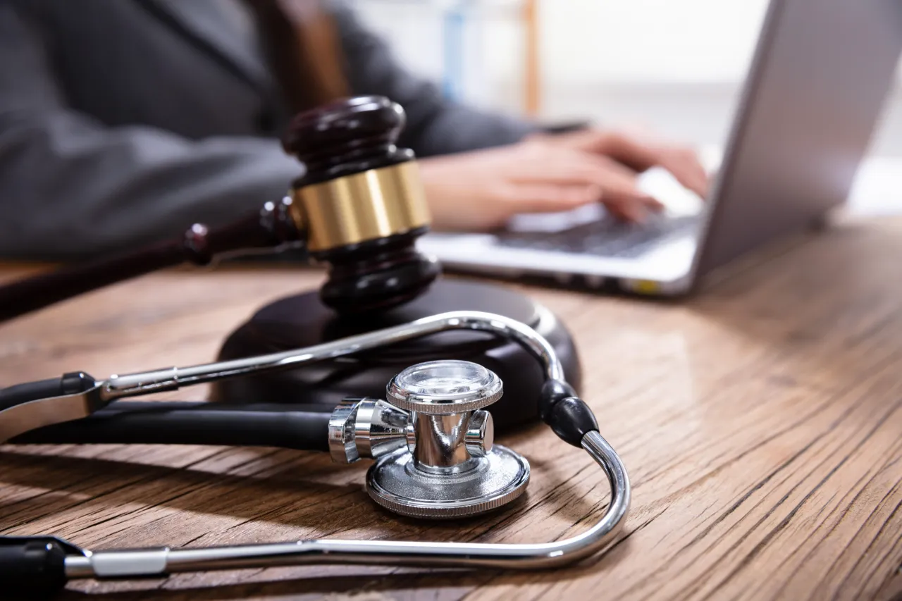 Seguro para profissionais liberais: médico e advogado revisando documentos técnicos e contrato em mesa de escritório