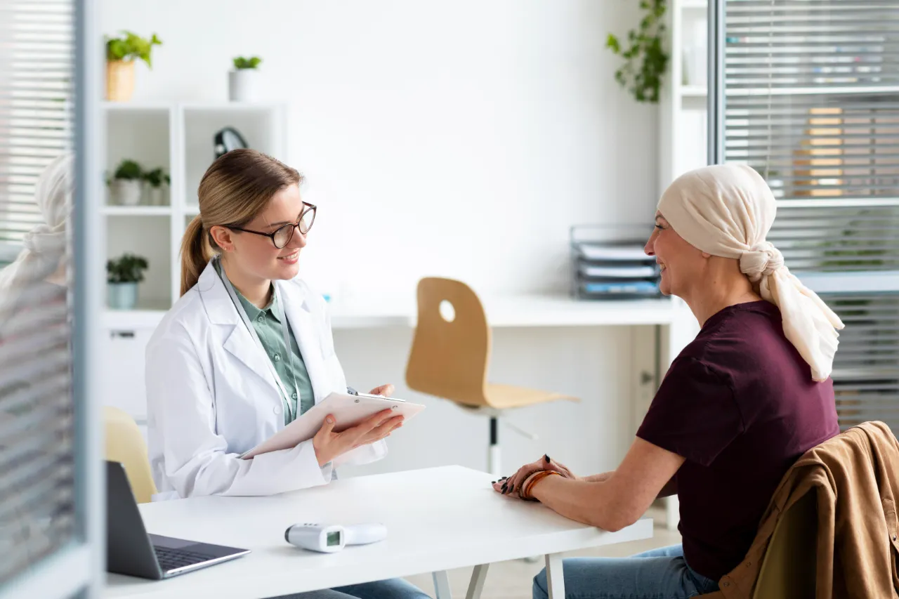 Seguro de vida para quem teve câncer: mulher conversa com a médica em consulta de acompanhamento